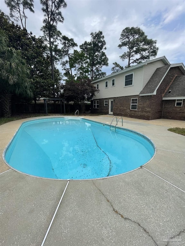 view of swimming pool featuring a patio area and fence
