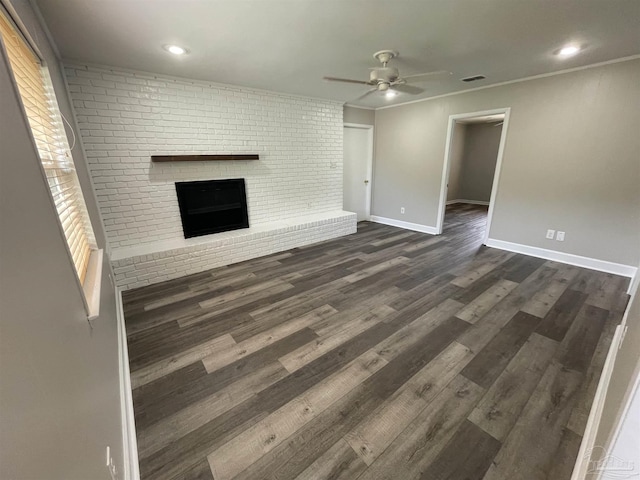 unfurnished living room featuring ceiling fan, a brick fireplace, dark wood-style floors, baseboards, and recessed lighting