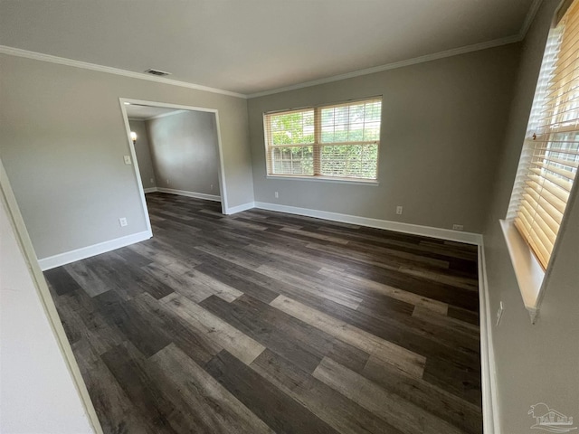 spare room with dark wood finished floors, baseboards, and crown molding