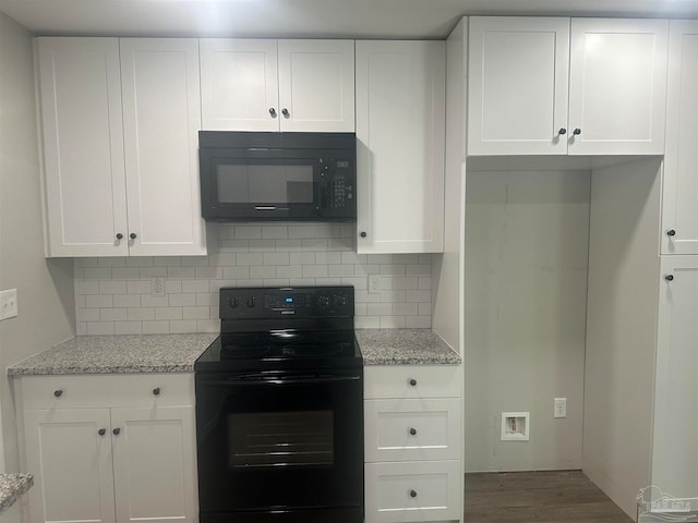 kitchen with light stone counters, white cabinetry, wood-type flooring, and black appliances