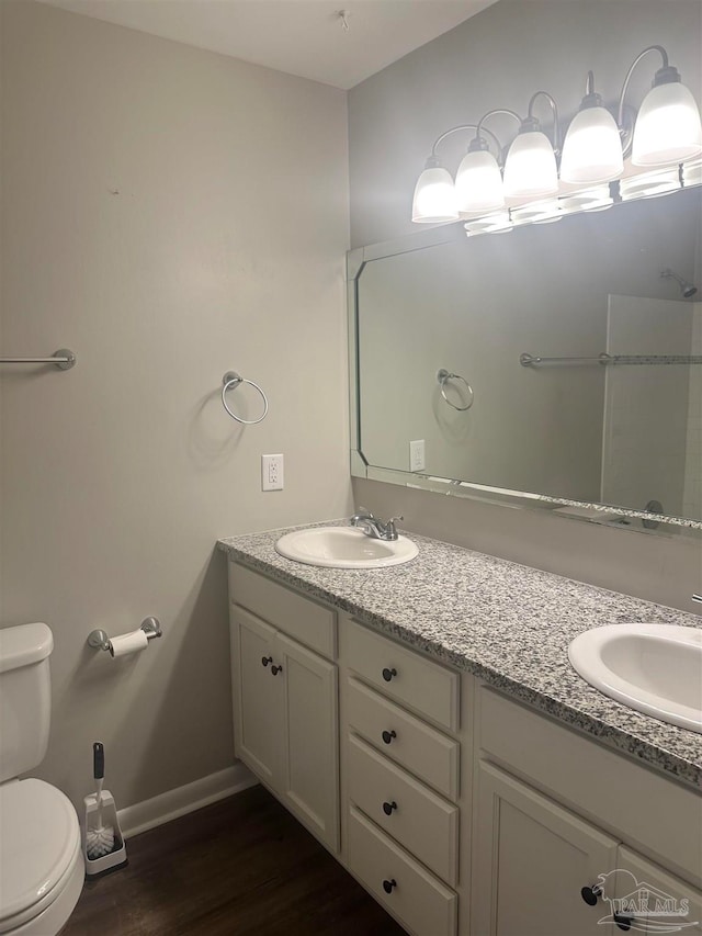 bathroom featuring hardwood / wood-style flooring, toilet, and vanity