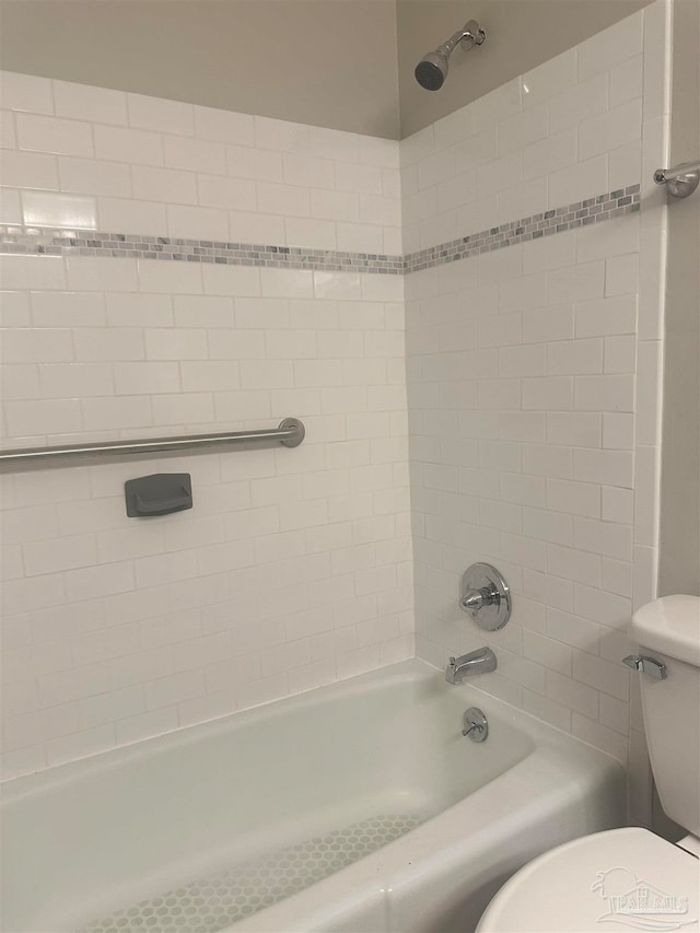 bathroom featuring tiled shower / bath and toilet