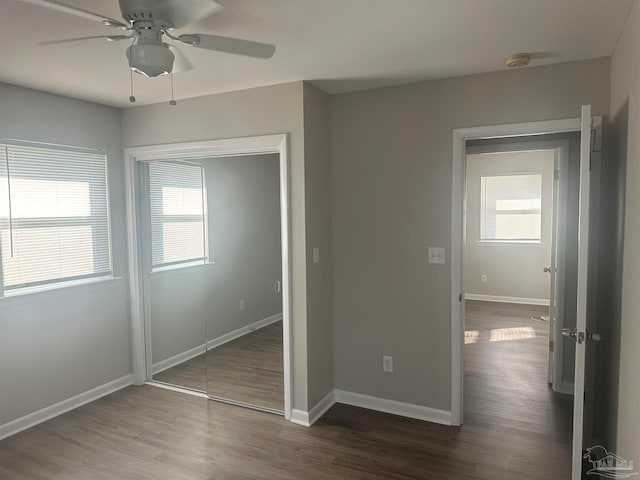 unfurnished bedroom with ceiling fan, a closet, and dark hardwood / wood-style floors