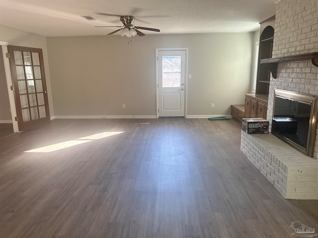 unfurnished living room featuring ceiling fan, a fireplace, and dark hardwood / wood-style floors