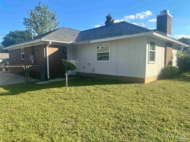 rear view of property featuring a lawn