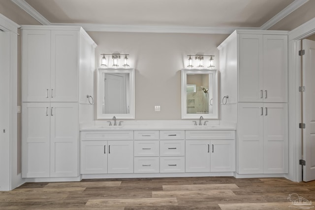 bathroom with wood-type flooring, vanity, and crown molding