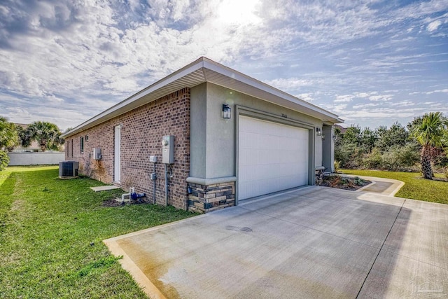 view of side of home with a garage, central AC, and a lawn