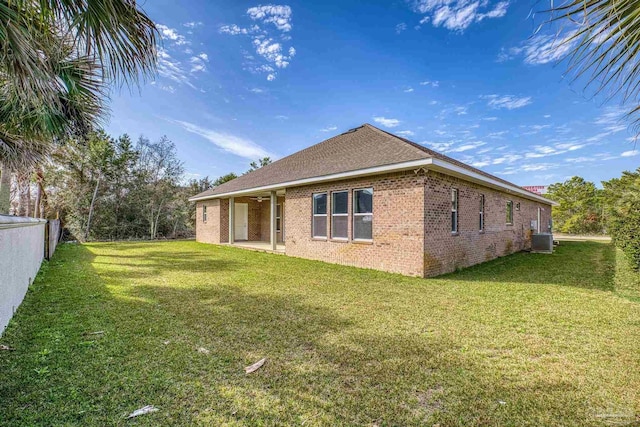 back of property featuring a yard and central AC unit