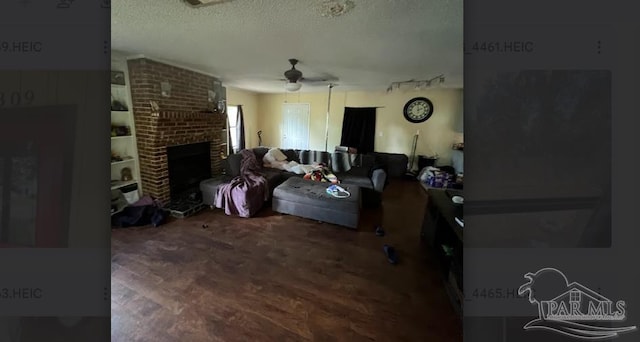 carpeted living room featuring ceiling fan, a textured ceiling, and a brick fireplace