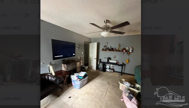 living room featuring a textured ceiling, carpet floors, and ceiling fan