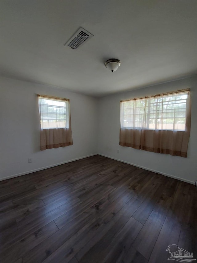 unfurnished room with dark hardwood / wood-style flooring