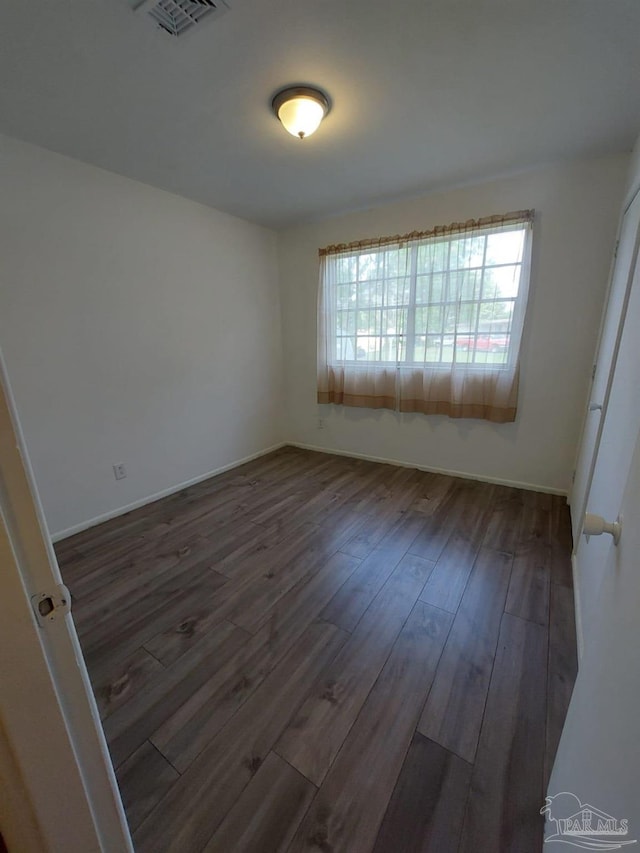 unfurnished room with dark hardwood / wood-style flooring