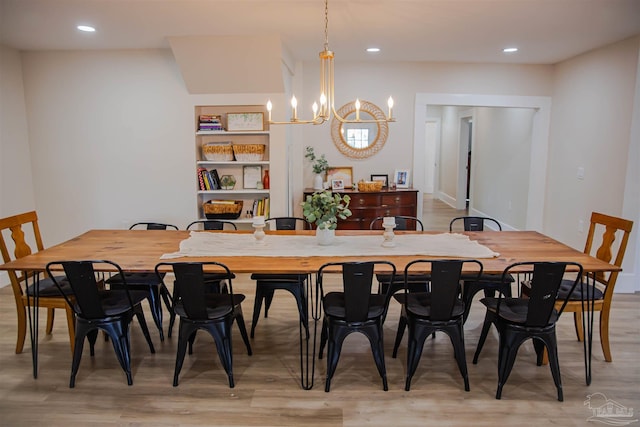 dining area featuring light wood-type flooring and an inviting chandelier