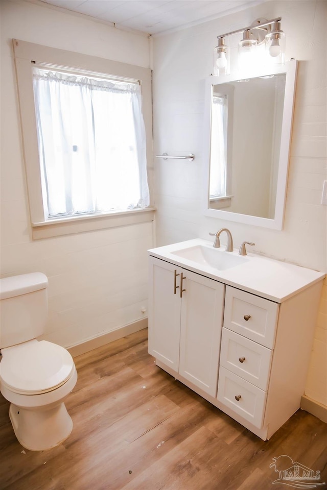 bathroom featuring wood-type flooring, toilet, and vanity