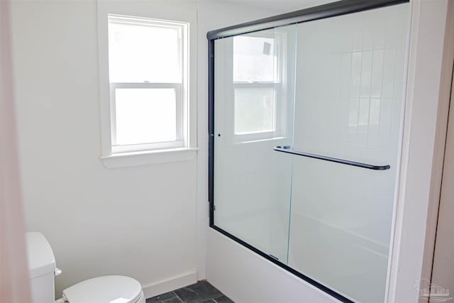 bathroom featuring toilet, enclosed tub / shower combo, and tile patterned flooring