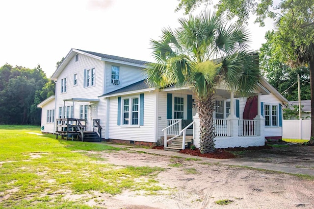 rear view of house with a lawn and a porch