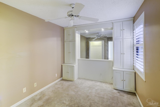 2007 E Gadsden St Unit 102, Pensacola, FL 32501 - unfurnished bedroom featuring baseboards, light carpet, a ceiling fan, and a textured ceiling