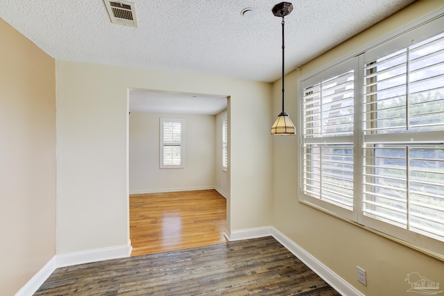 2007 E Gadsden St Unit 102, Pensacola, FL 32501 - unfurnished dining area with wood finished floors, a textured ceiling, and baseboards