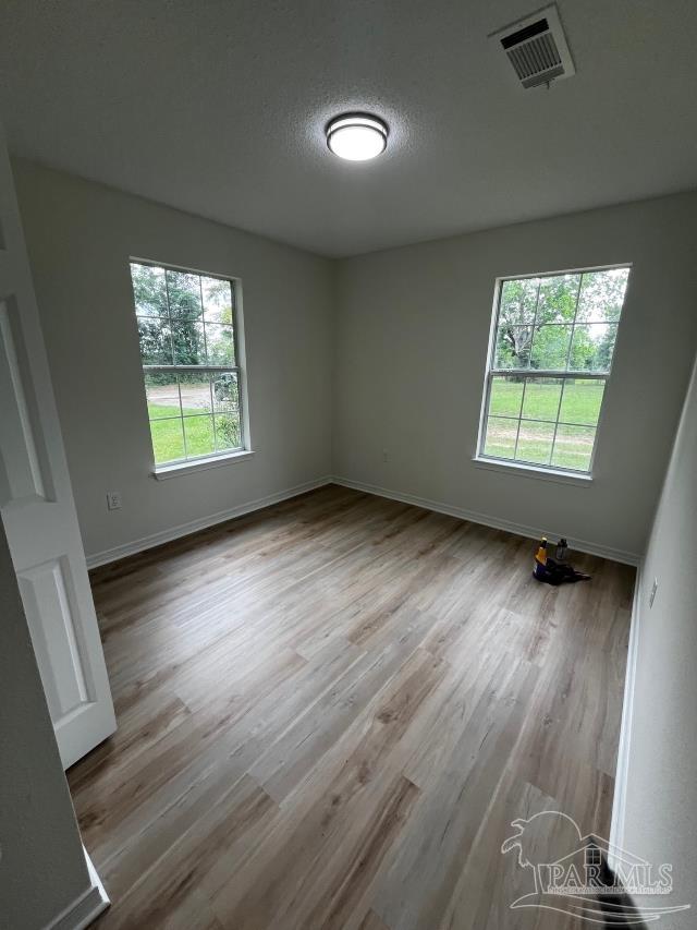1984 Hillary Thompson Rd, Milton, FL 32570 - spare room featuring wood finished floors and baseboards