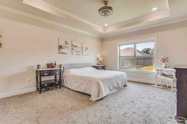 carpeted bedroom featuring a tray ceiling and crown molding