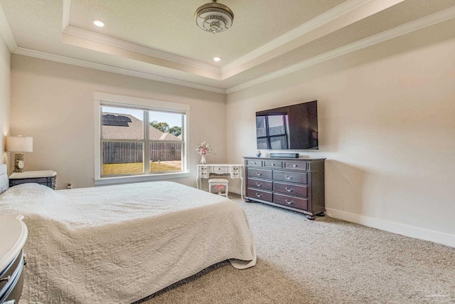 carpeted bedroom with crown molding and a tray ceiling