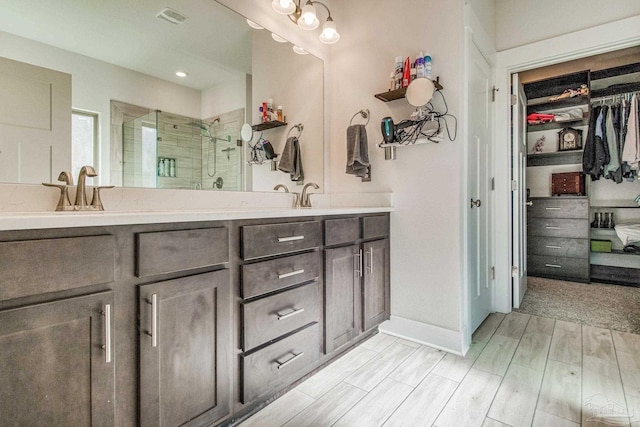 bathroom featuring hardwood / wood-style flooring, vanity, and walk in shower