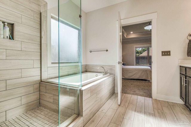 bathroom with wood-type flooring, vanity, and shower with separate bathtub