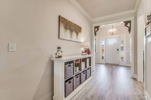 entryway with hardwood / wood-style floors, a notable chandelier, and crown molding