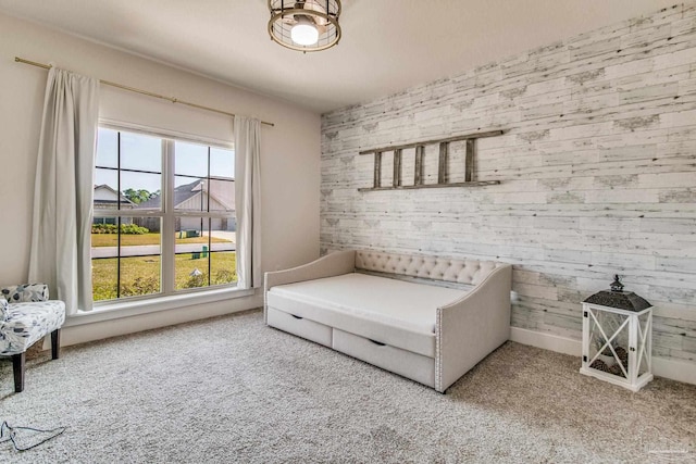 living area with carpet floors, a wealth of natural light, and wood walls