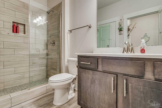 bathroom with vanity, wood-type flooring, a shower with shower door, and toilet