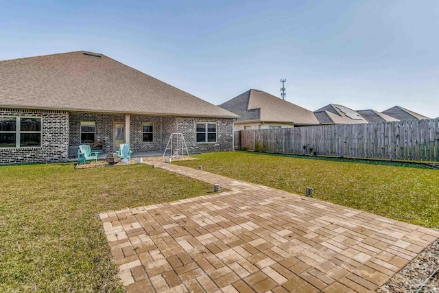 back of property with a lawn and a patio