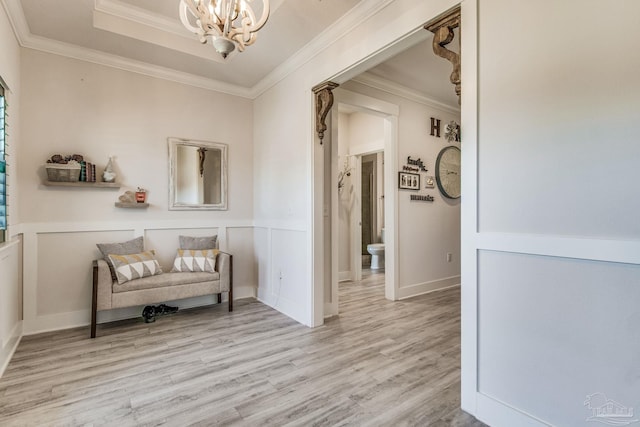 sitting room featuring an inviting chandelier, crown molding, and light hardwood / wood-style flooring