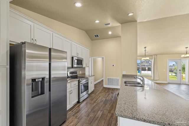 8114 Silver Maple Dr, Milton, FL 32583 - kitchen featuring stainless steel appliances, a chandelier, a peninsula, white cabinetry, and vaulted ceiling