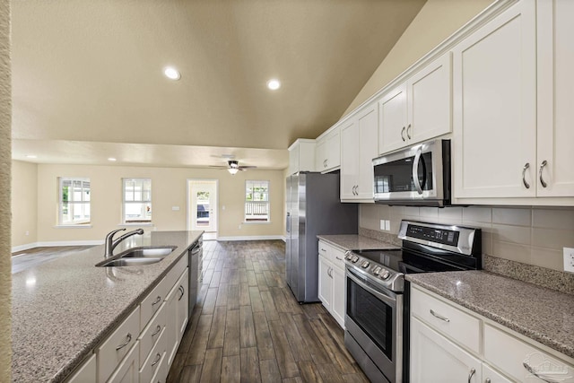 8114 Silver Maple Dr, Milton, FL 32583 - kitchen featuring appliances with stainless steel finishes, white cabinetry, light stone countertops, tasteful backsplash, and dark wood-style flooring