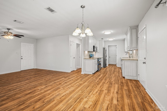 kitchen with light wood-type flooring, visible vents, appliances with stainless steel finishes, and decorative backsplash