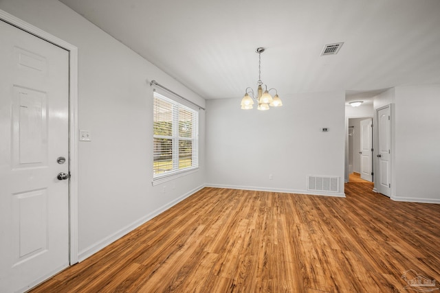 unfurnished dining area with visible vents, baseboards, and wood finished floors