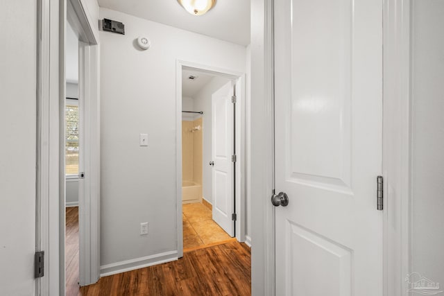 hallway with wood finished floors and baseboards