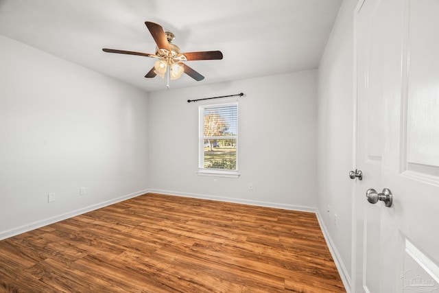 spare room with a ceiling fan, baseboards, and wood finished floors