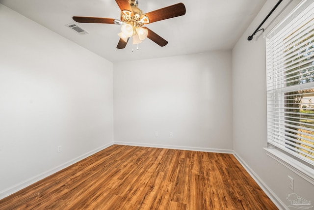 unfurnished room with a ceiling fan, baseboards, visible vents, and wood finished floors