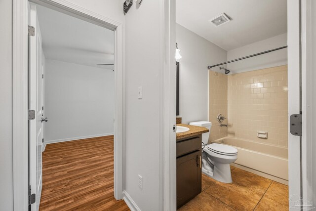 bathroom with visible vents, toilet, tub / shower combination, vanity, and tile patterned flooring