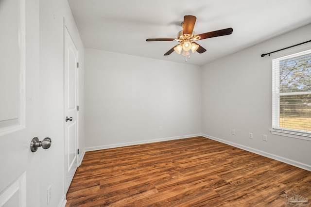 empty room featuring wood finished floors, a ceiling fan, and baseboards