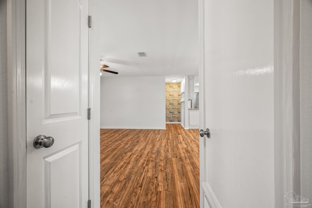 corridor featuring dark wood-type flooring, visible vents, and baseboards