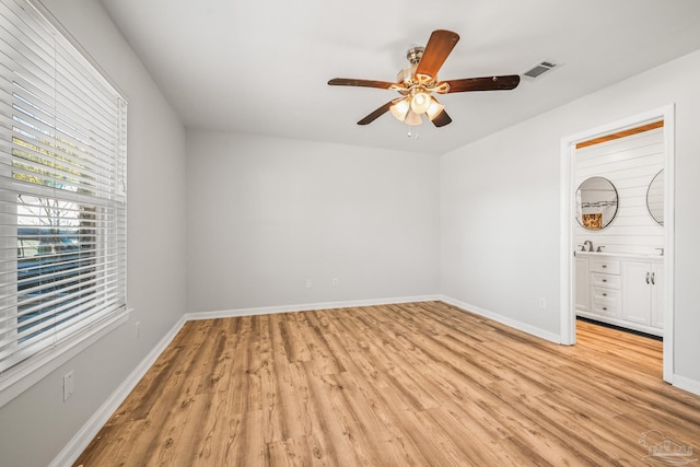 unfurnished bedroom with light wood finished floors, a ceiling fan, visible vents, and baseboards