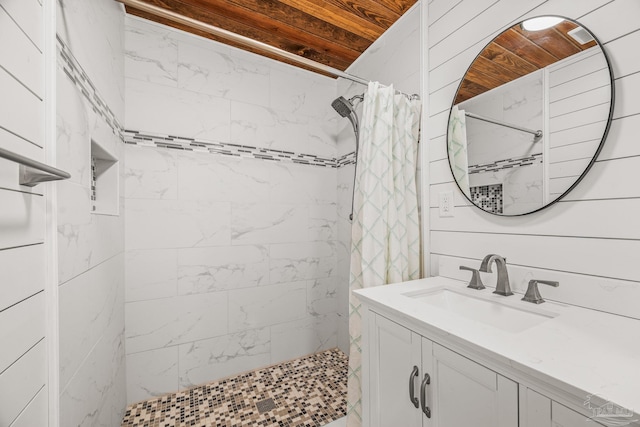 full bathroom featuring wooden ceiling, a tile shower, and vanity