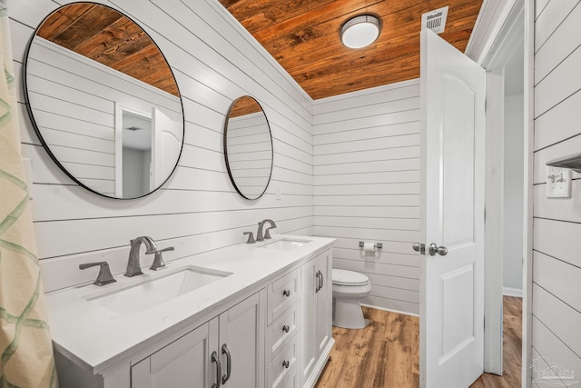 full bath with wooden ceiling, a sink, toilet, and wooden walls