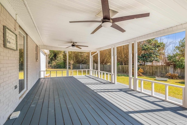 deck featuring ceiling fan, a lawn, and a fenced backyard