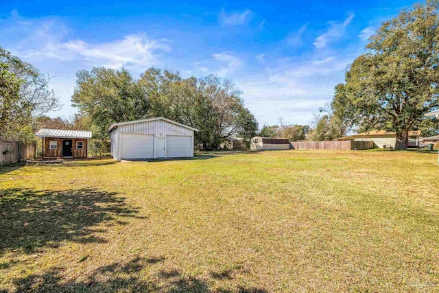 view of yard with an outbuilding, fence, and a detached garage