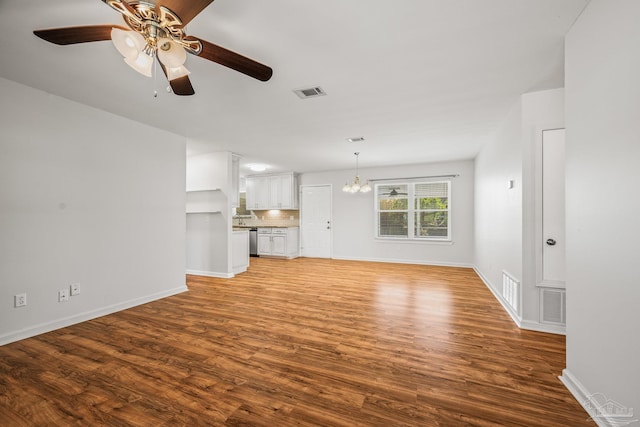 unfurnished living room featuring baseboards, visible vents, and wood finished floors