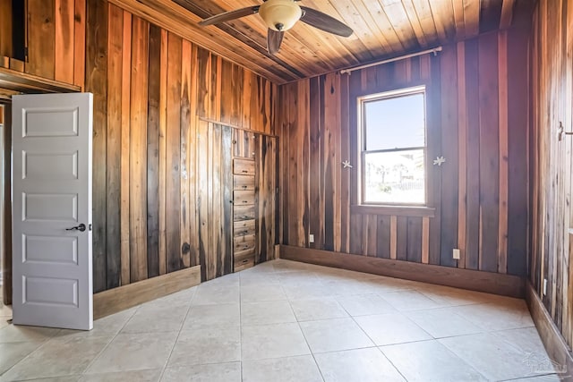 spare room featuring light tile patterned floors, ceiling fan, wooden ceiling, and wooden walls