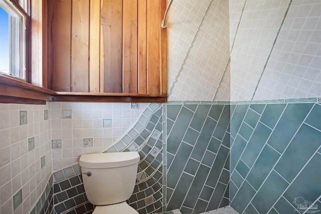 bathroom featuring toilet, tile walls, and tile patterned floors